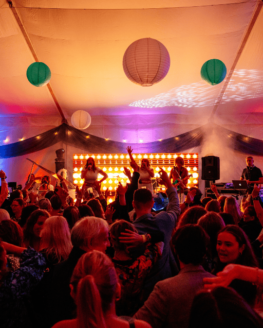 Abba tribute band on stage with orange lights and a dancing crowd