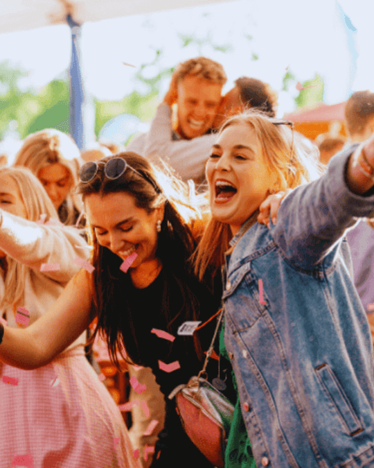 Young Women dance and Sing in a crowd