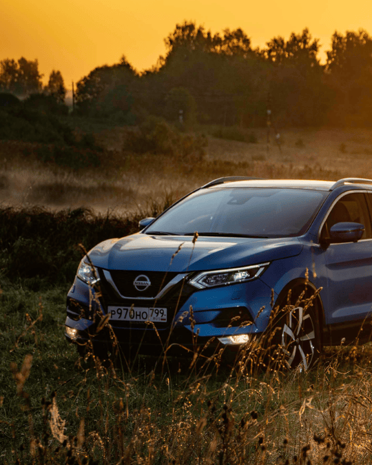 Car parked in a car park located in a field at sunset