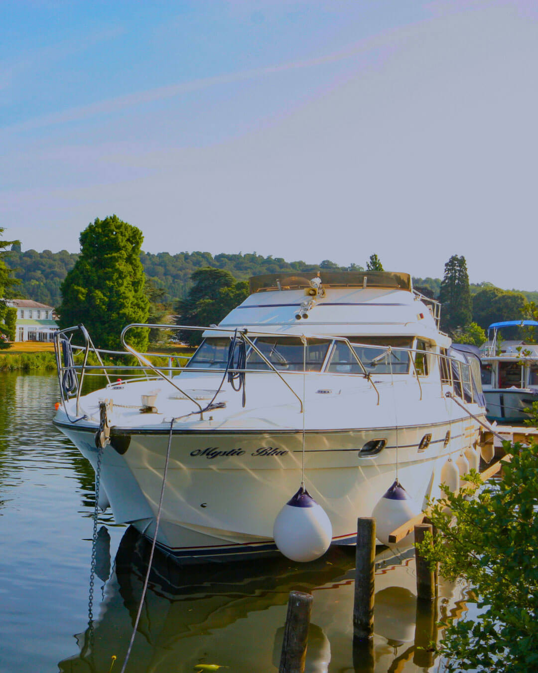 large white boat moored moored along the river thames with blue sky