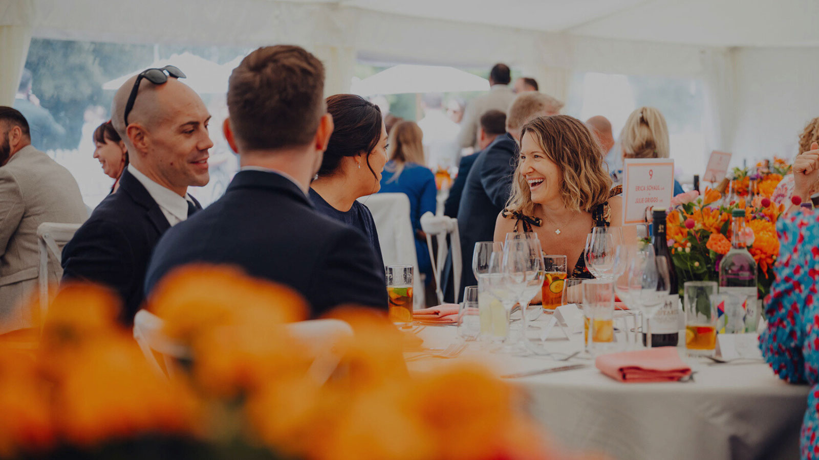 People sitting at a table in a hospitality venue laughing and talking