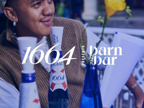 Man sits at a table in front of bottles of 1664 beer