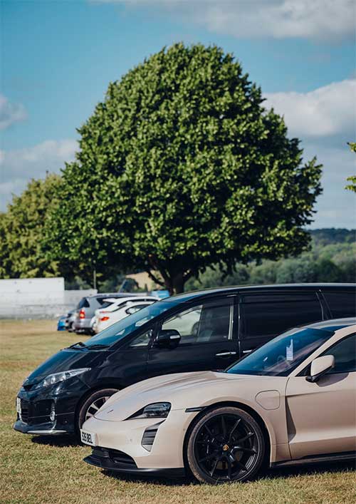 luxury cars parked in a sunny field