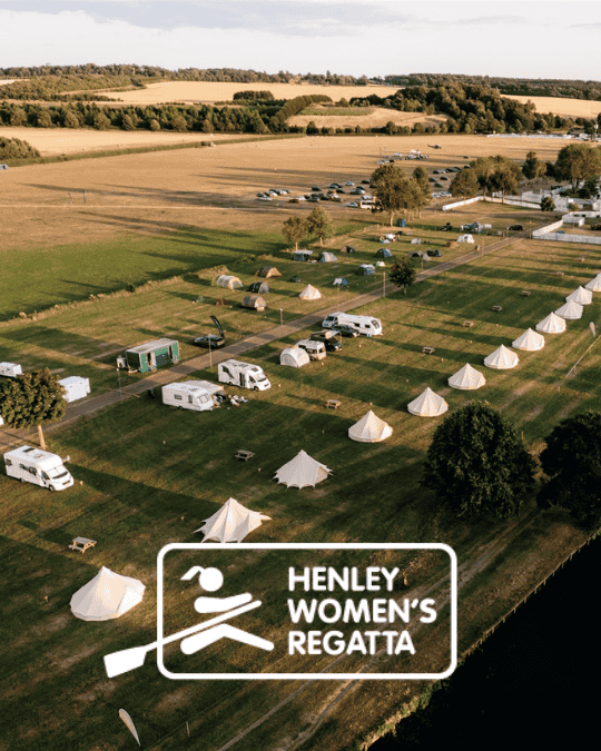 Bell tents and campervans parked along a river in the setting sun