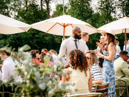 Guests enjoying premium riverside hospitality under parasols at Remenham Farm during Henley Royal Regatta.